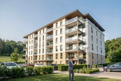 Syndic de copropriété dans l'Ain : vue d'un immeuble résidentiel moderne avec un gestionnaire professionnel devant l'entrée
